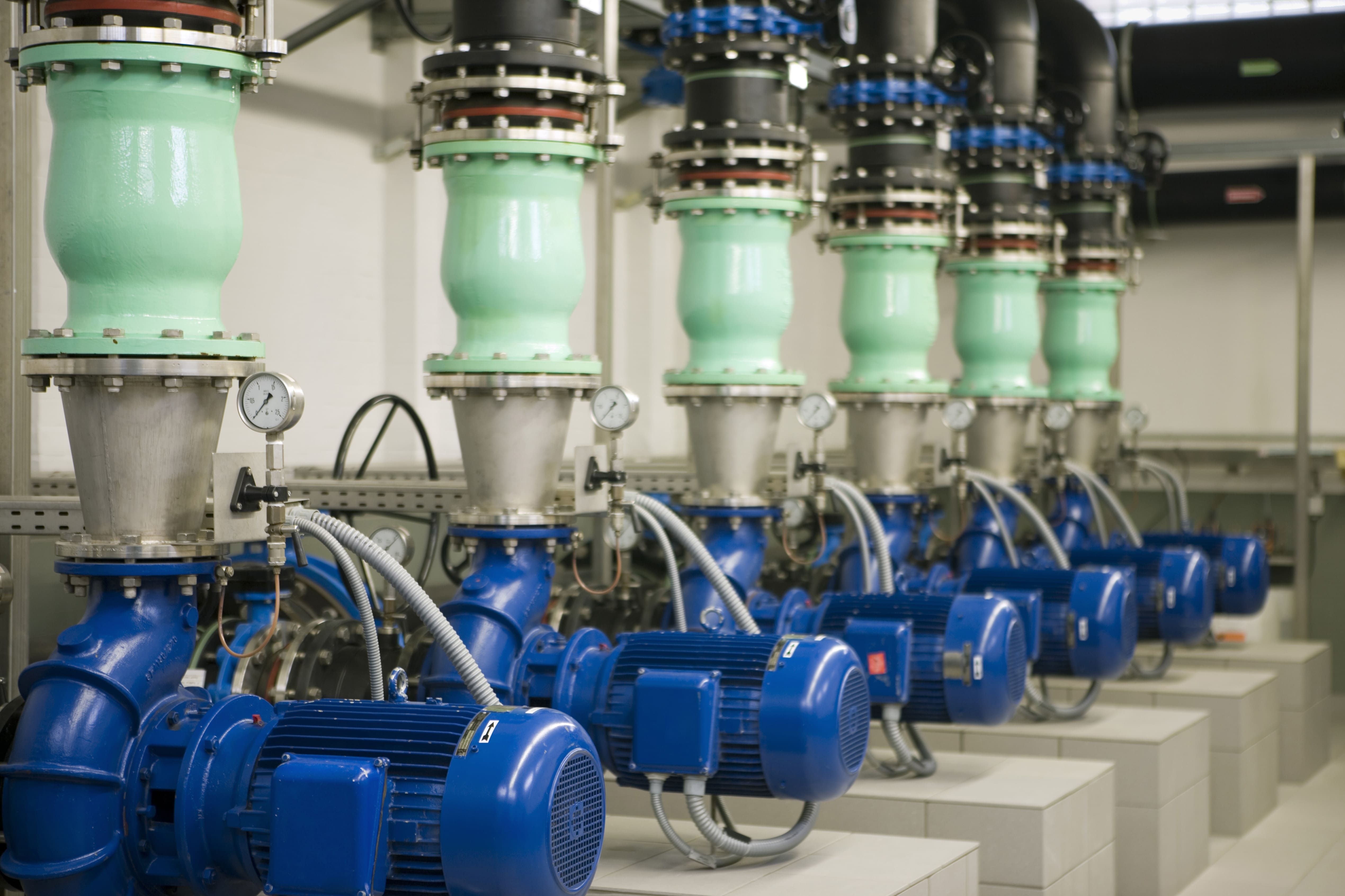 Conjunto de bombas centr&iacute;fugas instaladas em ambiente industrial, representando sistemas de bombeamento sujeitos a problemas como cavita&ccedil;&atilde;o.