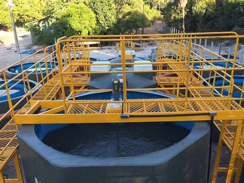Misturadores industriais em uma esta&ccedil;&atilde;o de tratamento de efluentes abaixo de plataformas industriais amarelas